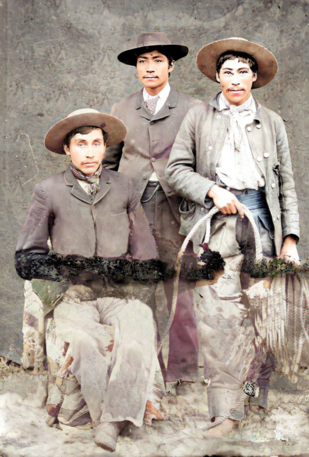 Photo en studio de trois cowboys accoutrés
