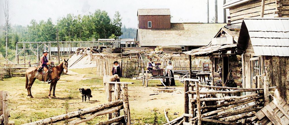 Homme à cheval, chien et charette devant bâtiments et clôtures en bois