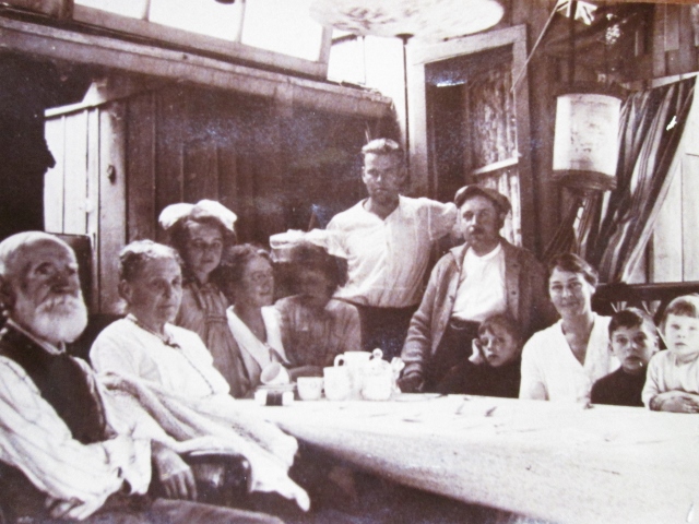 Image d’une photo en noir et blanc de 11 personnes assises à la table sur le perron