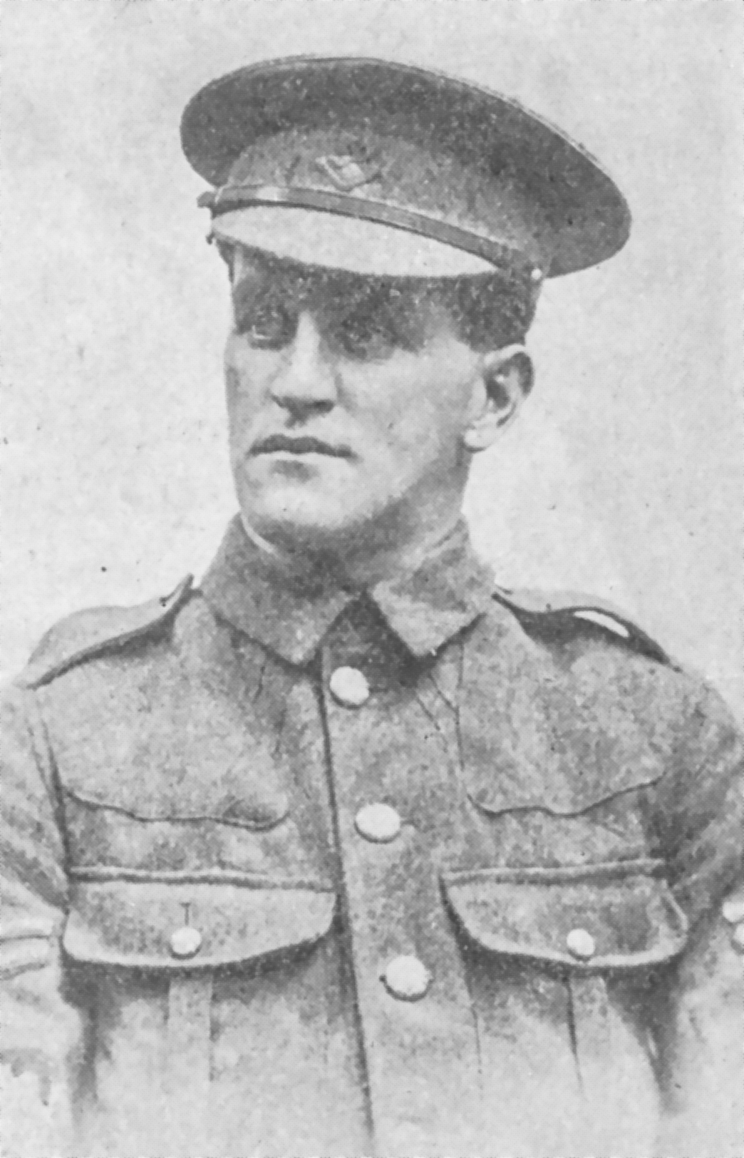 Photographie d’archive en noir et blanc d’un homme en uniforme portant une casquette à visière.