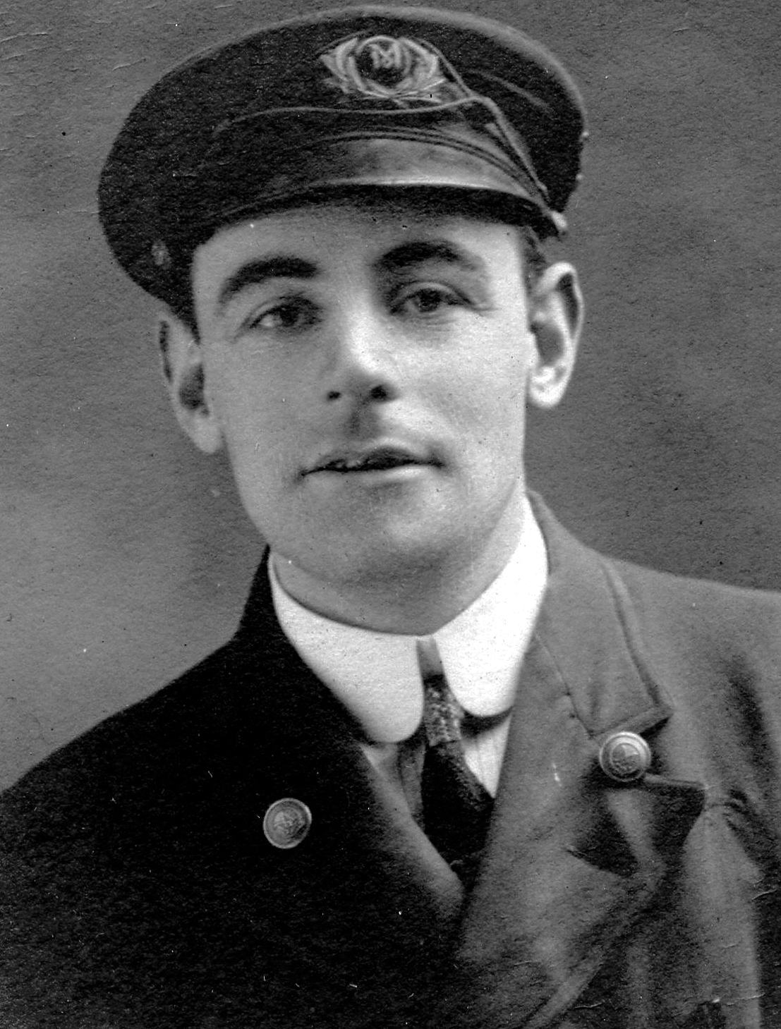 Photographie d’archive en noir et blanc d’un homme en uniforme avec une casquette à visière