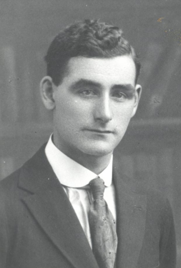Photographie d’archive en noir et blanc d’un homme en costume-cravate.