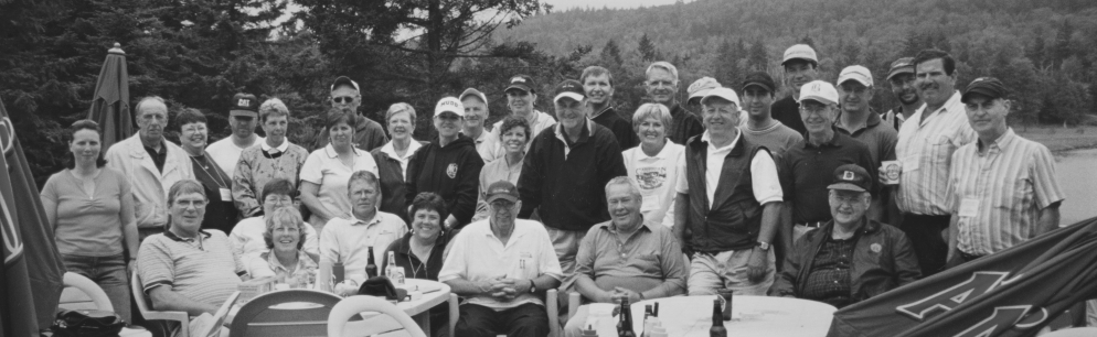 Photo de groupe de vingt-et-un hommes et douze femmes sur la terrasse d’un club de golf