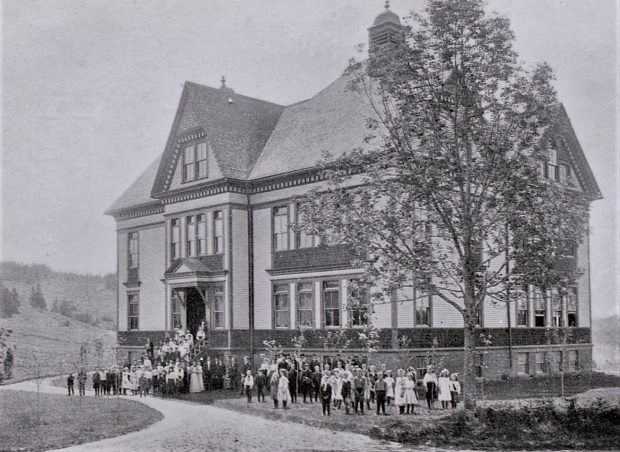 L’école avec des élèves et des enseignants sur le perron et la pelouse