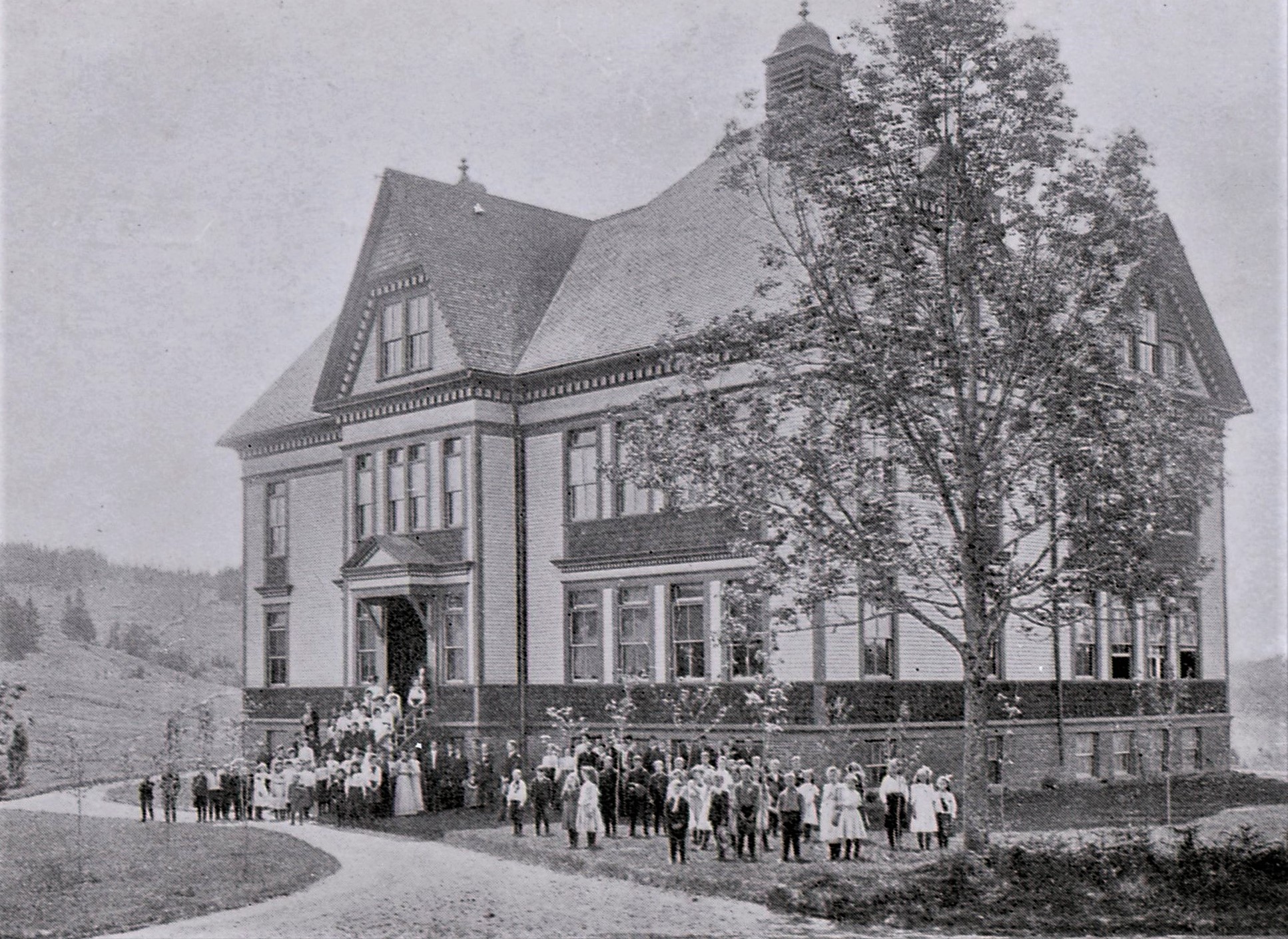 L’école avec des élèves et des enseignants sur le perron et la pelouse