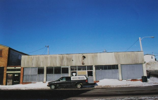 Photographie couleur.  Vue extérieure du magasin Stewart’s. Le bâtiment a été construit dans les années 1950, suite à un incendie sur la rue Main de Windsor. Un camion est garé devant le bâtiment.