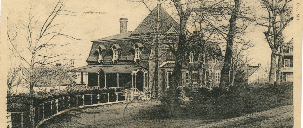Illustration en noir et blanc d’une grande maison cossue avec galerie, bay-window et toit en mansarde. Des arbres matures sont plantés en façade.
