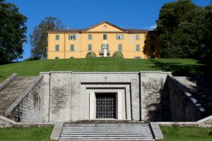 Un manoir jaune de trois étages se dresse au sommet d'une colline. Au pied de la colline se trouve l'entrée d'un mausolée en pierre grise. L'inscription « Guglielmo Marconi » est gravée au-dessus de la porte.