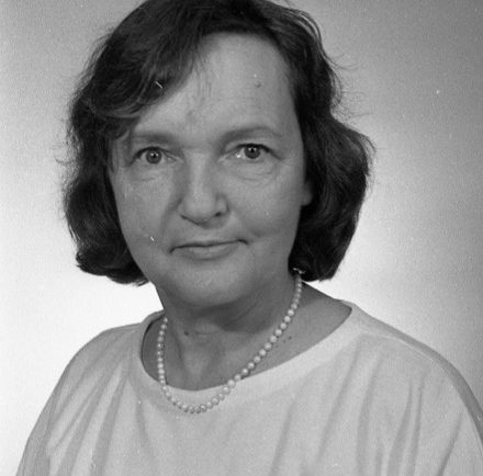 Photographie en noir et blanc de la journaliste Doris Veillette Hamel. Elle porte un chandail ainsi qu’un collier de perles.  