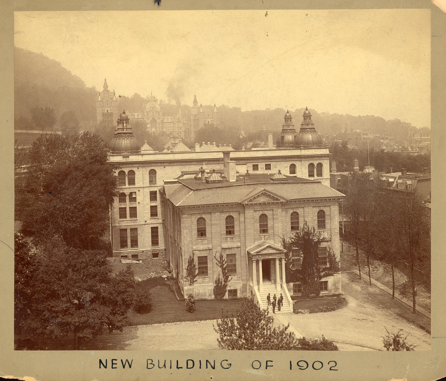 Image aux tons sépia d'un grand bâtiment néoclassique en pierre. 