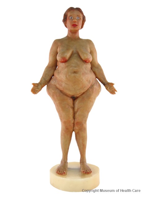 Photo en couleur du modèle en cire d'une femme nue se tenant debout les bras ouverts. 