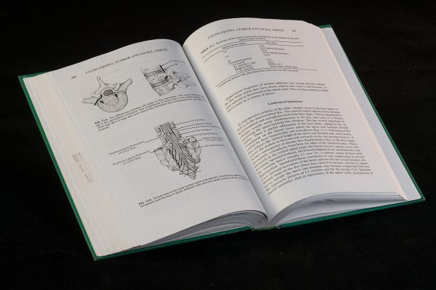 Photo en couleur d'un livre ouvert sur des illustrations médicales et du texte.