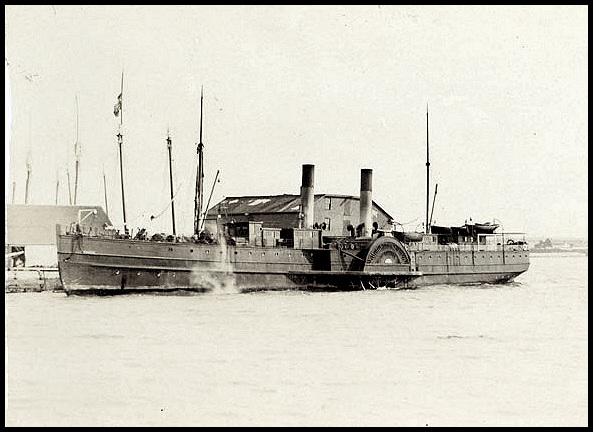 Photographie sépia d'un bateau à vapeur à deux aubes amarré a un quai. Le bateau est de taille moyenne et présente 2 cheminées. Sur le pont arrière sont entreposé les barques de sauvetage et quelques passagers sont présent sur le pont avant.