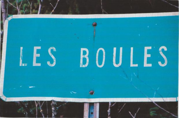 Photographie couleur du panneau routier présentant le village de Les Boules.