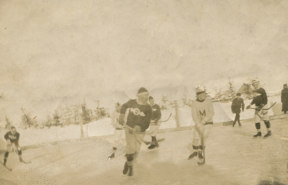 Image sépia de cinq jeunes joueurs de hockey sur une patinoire extérieure à Métis.