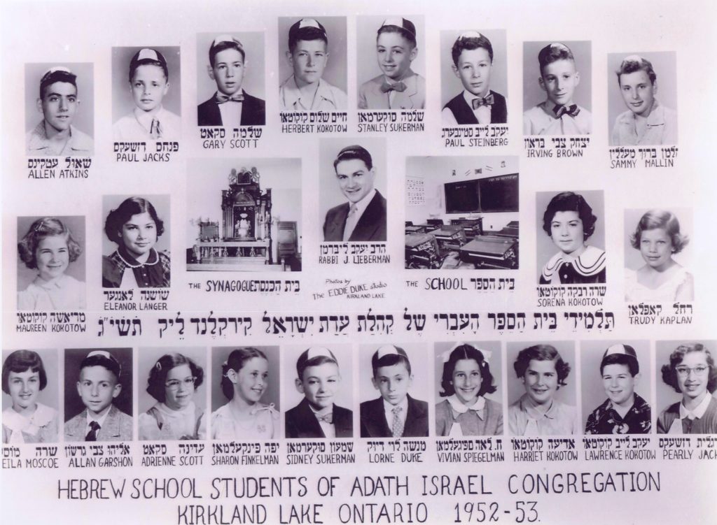 Photographie en noir et blanc d’élèves de l’école hébraïque de Kirkland Lake. Des photos de portraits de 22 garçons et filles ainsi que du rabbin sont disposées sur trois rangées. Une photo de l’intérieur de l’école et de la synagogue se trouve au centre.