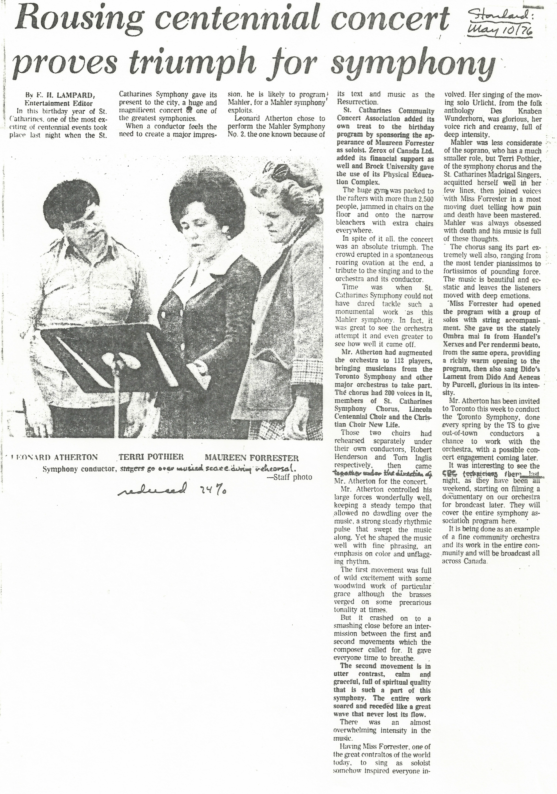 Leonard Atherton, Terri Pothier et Maureen Forrester regardent des partitions sur un pupitre. L’article du journal est « Le concert centenaire vibrant est un triomphe pour l’orchestre symphonique. » 