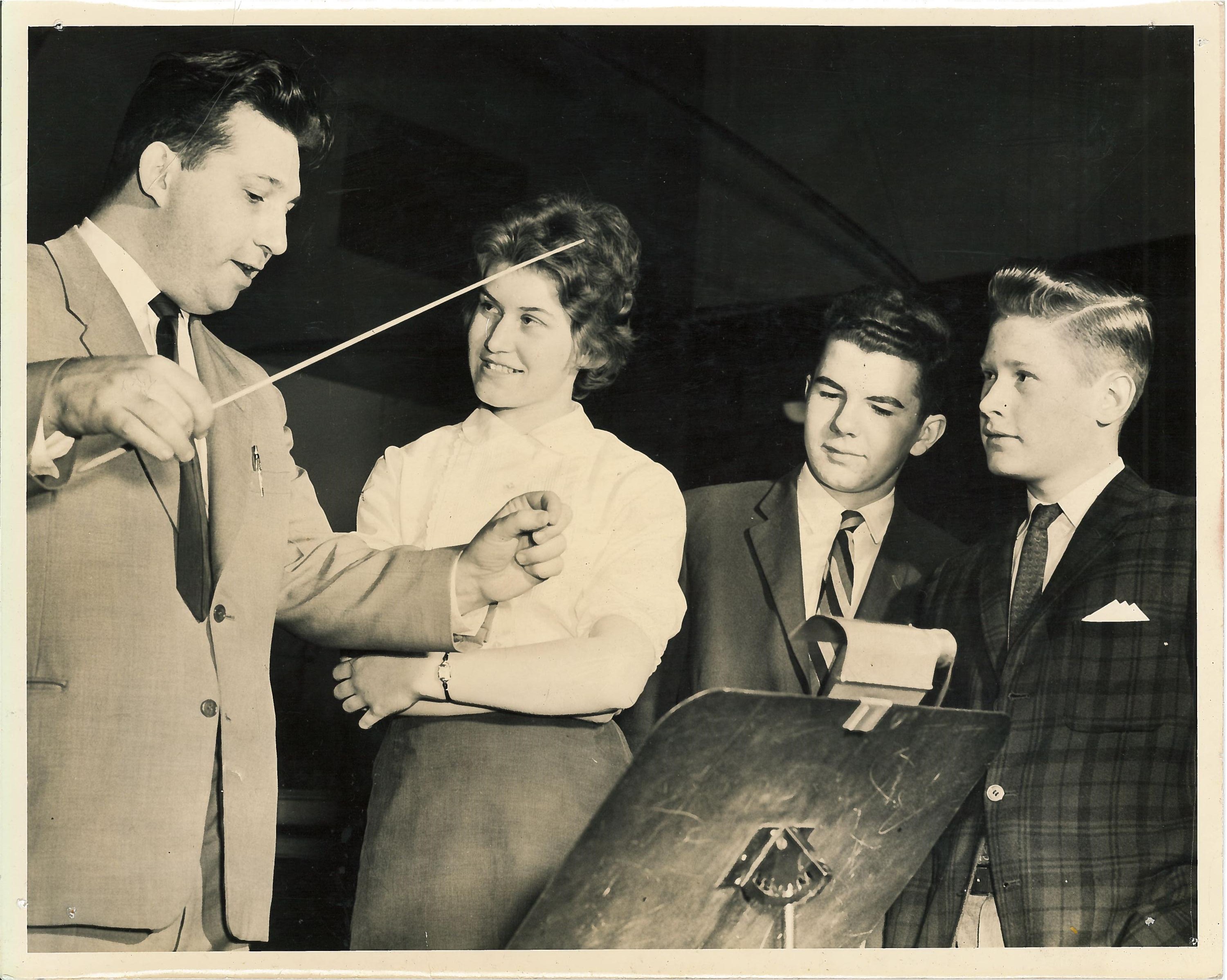 Leonard Pearlman démontre aux trois étudiants comment diriger un orchestre  
