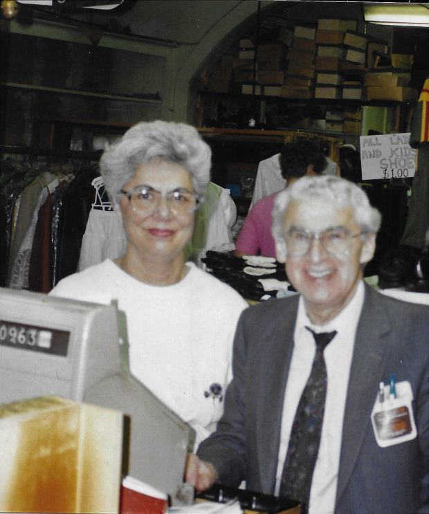 Un homme et une femme se tiennent debout derrière la caisse enregistreuse d’un magasin.