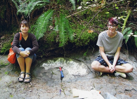 Elke et Enzo Wohlleben, accroupis près du fossile d’ammonite qu’ils ont découvert.