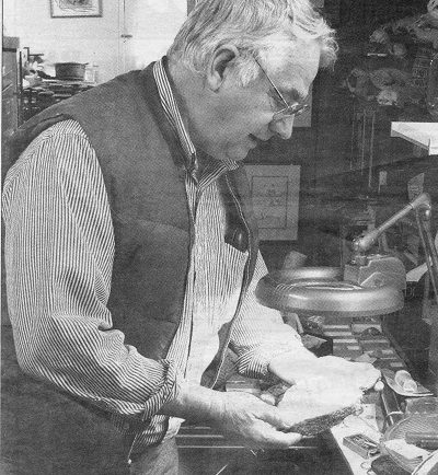 Graham Beard, chez lui, regardant un fossile sous une lampe. c. 1995