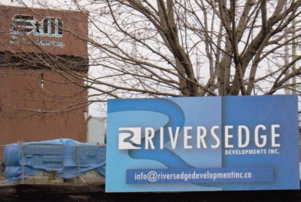 Photo de l'enseigne de Riversedge Developments Inc. sur la clôture de la propriété de la St. Mary's Paper Corp.