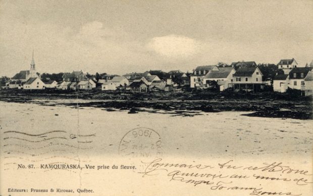 Carte postale sépia No. 87. KAMOURASKA. – Vue prise du fleuve (panoramique d’une petite municipalité côtière). Premier plan : étendue d’eau (fleuve Saint-Laurent). Sur la rive : maisons, église au clocher pointu. Inscriptions manuscrites en français. Timbre 1906. En bas à gauche : Editeurs: Pruneau & Kirouac, Québec..