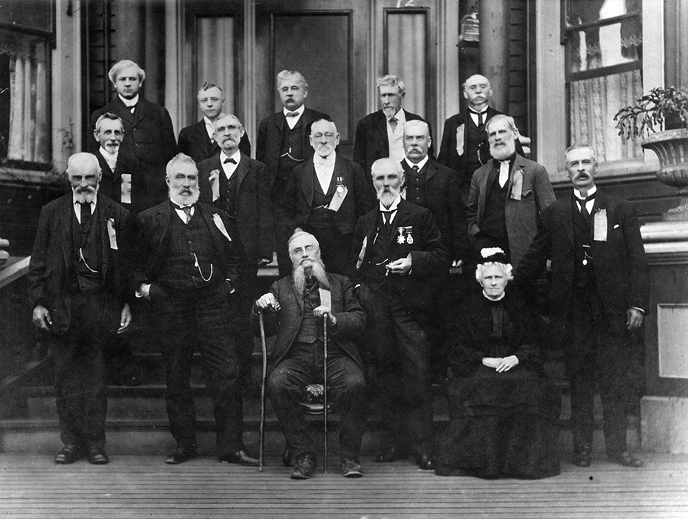 Une photo de groupe en noir et blanc d’une femme et quinze hommes en tenue officielle et disposés en trois rangs. Au nombre des personnes du premier rang se trouve Philip Jackman, âgé, debout à gauche. On voit aussi, dans ce premier rang, trois hommes debout, et un homme et une femme assis. Chacun des deux autres rangs est composé de cinq hommes debout sur les marches d’un escalier.