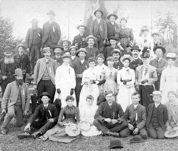 Une photographie de groupe en noir et blanc, où l'on voit six rangs inégaux d'homme, de femmes et d'enfants élégamment vêtus.