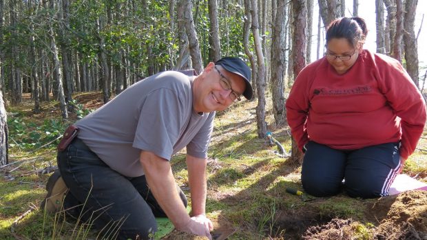 Deux fouilleurs autours d'un sondage dans le bois