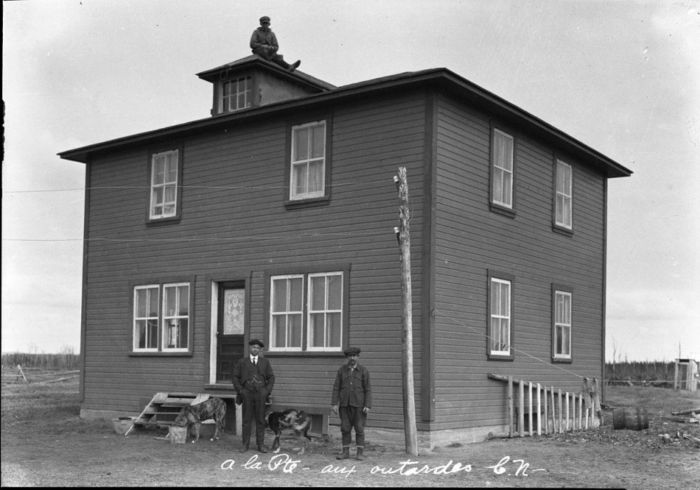 maison en bois avec trois hommes et deux chiens