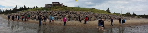 Plusieurs personnes marchant le long de la plage en contrebas d'un bâtiment