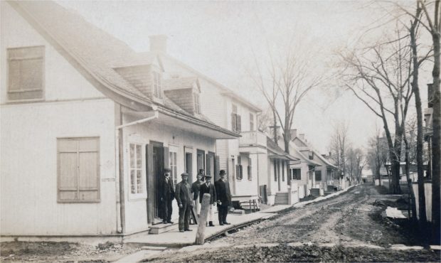 Une rue en terre avec des maisons ancestrales et des hommes