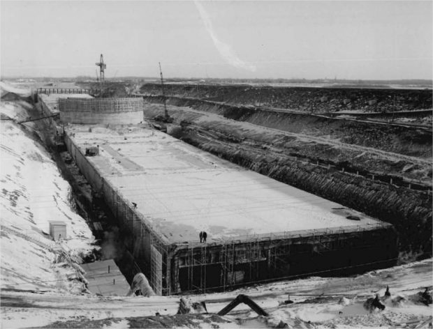 Une structure de béton en construction dans une tranchée avec une grue