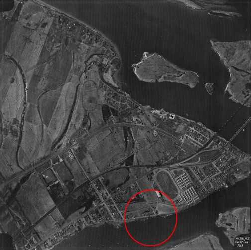 Une photographie aérienne d'une ville peu habitée avec un cercle rouge près d'un cours d'eau