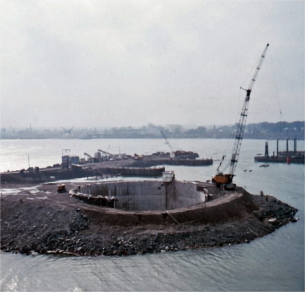 Une grue sur une structure de béton entourée de terre et d'eau