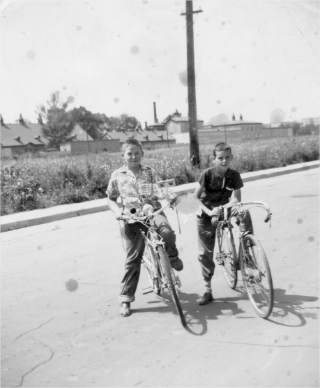 Deux enfants sur leurs bicyclettes sur une rue de Boucherville