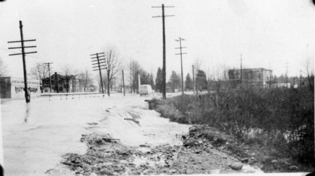 Une voiture roulant sur une route inondée.