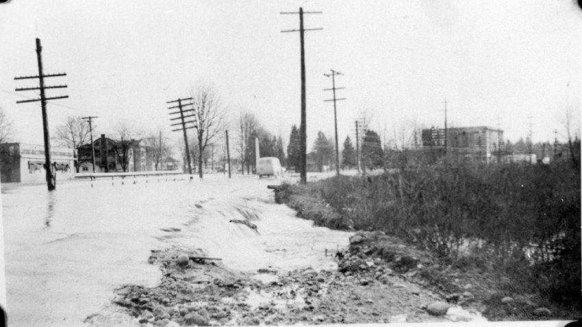 Une voiture roulant sur une route inondée.