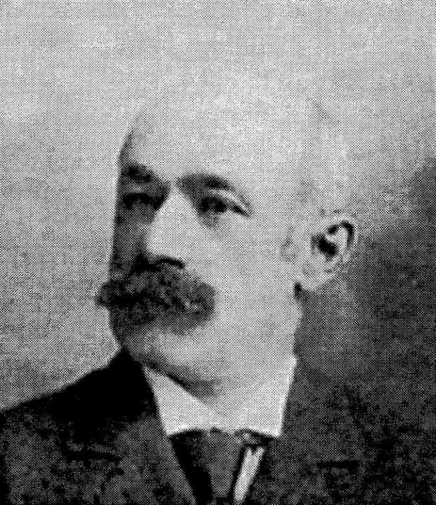 Photographie d’archives en noir et blanc. Il s’agit d’un portrait trois-quarts d’Arthur Toussaint qui porte la moustache et un complet-cravate.