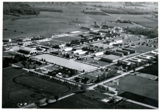 Vue aérienne en noir et blanc d'une base des Forces aériennes ; des champs de fermes sont visibles au loin.