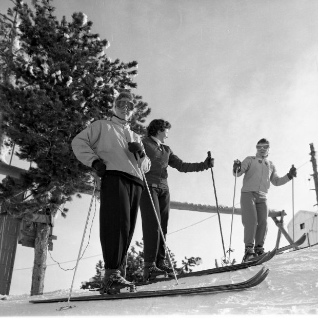Photo en noir et blanc de trois skieurs femelles dans les années 1950. 