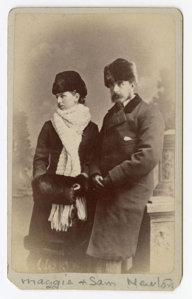 Photographie en noir et blanc d’une femme et d’un homme vêtus de manteaux et coiffés de chapeaux de fourrure.