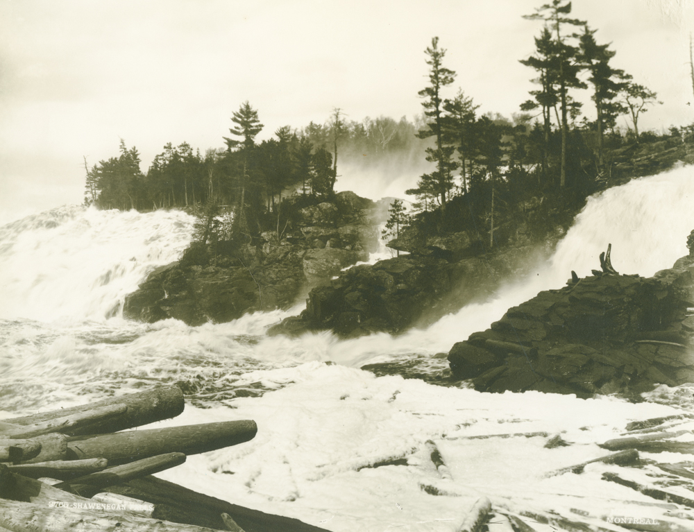 L'eau descend violemment les chutes de Shawinigan, divisé en trois branches, à travers les rochers et les amoncellements de billots de bois.