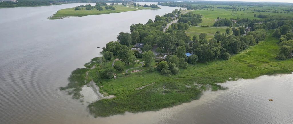 Image en couleur d’une vue aérienne de la pointe est de l’île en été. On voit la rivière des Prairies à gauche et la rivière des Mille-Îles à droite. Elles se rejoignent au bas de l’image. 
