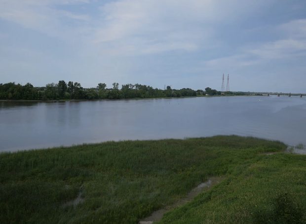 La vidéo débute au-dessus de la berge de l’est de l’île en été. Les arbres et l’herbe sont vert foncé. La caméra monte progressivement au-dessus des arbres. La rivière des Mille-Îles apparait. La caméra tourne pour découvrir le confluent des deux rivières. On voit au loin le pont Charles-De-Gaulle de Repentigny et le fleuve Saint-Laurent. Un bateau navigue sur l’eau et des voitures circulent sur le pont.