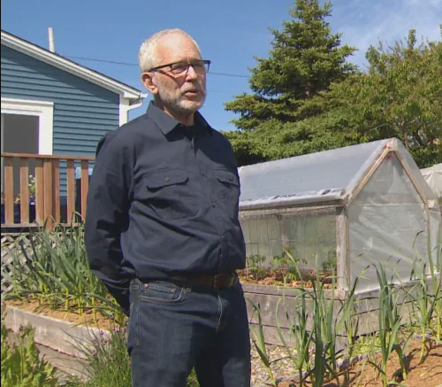  Dan Rubin debout devant un jardin et une serre