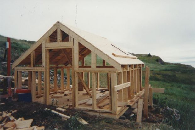 Extérieur de la remise d’une cave à légumes en cours de construction avec du bois.