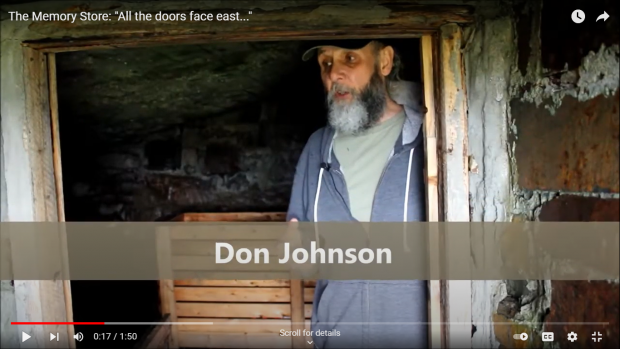 Homme barbu d'âge moyen avec casquette debout dans la porte ouverte d'une cave à legumes.