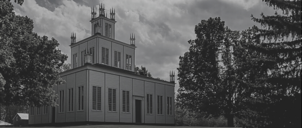 Photo en noir et blanc du temple de Sharon. L’édifice est formé de trois carrés superposés de taille décroissante, et il est entouré de grands érables. 